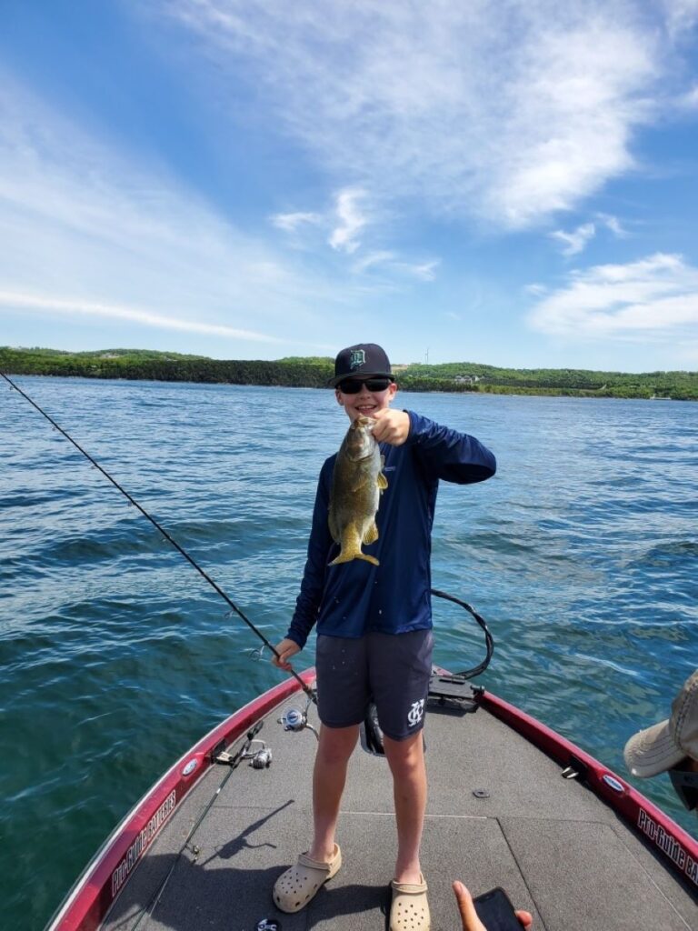 Boy holding up fish he just caught on Table Rock Lake.