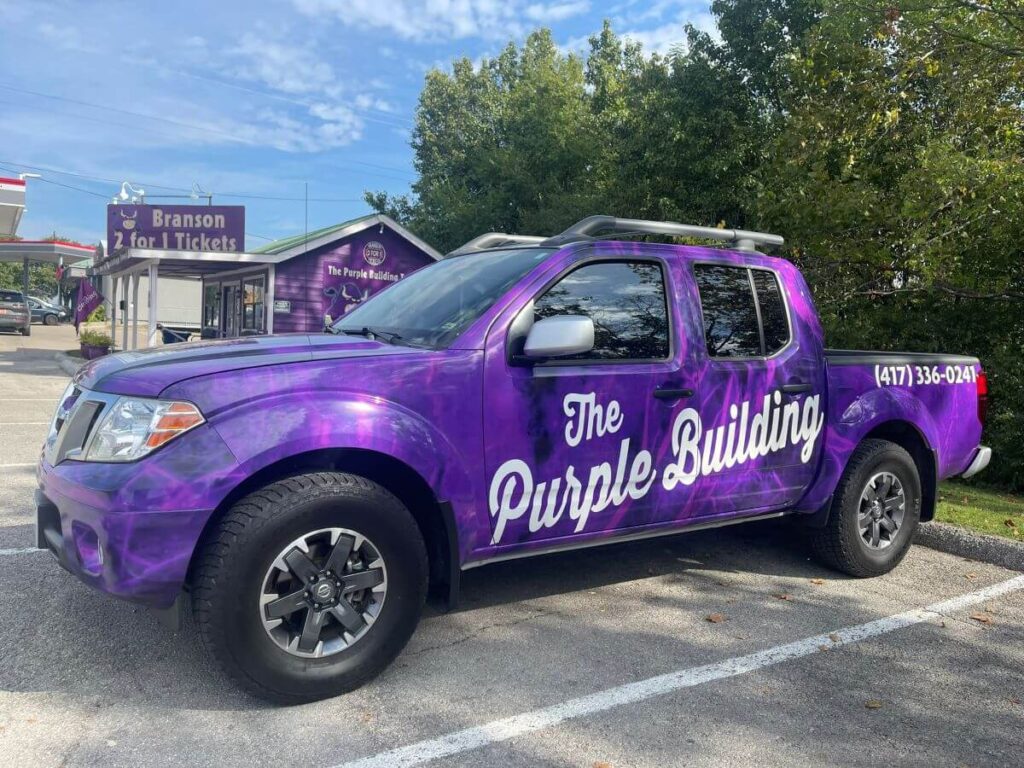 Photo of Branson 2-for-1 Ticket's purple truck with "The Purple Building" on the side of the truck.