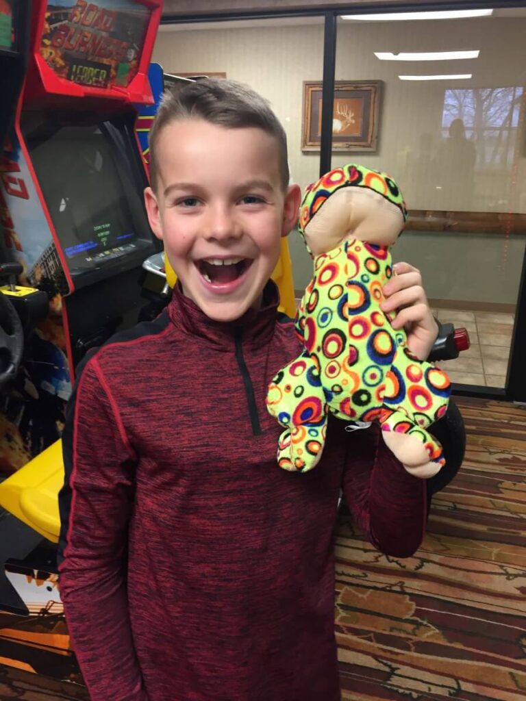 Boy holding toy won in the game room at Comfort Inn & Suites Branson Meadows.