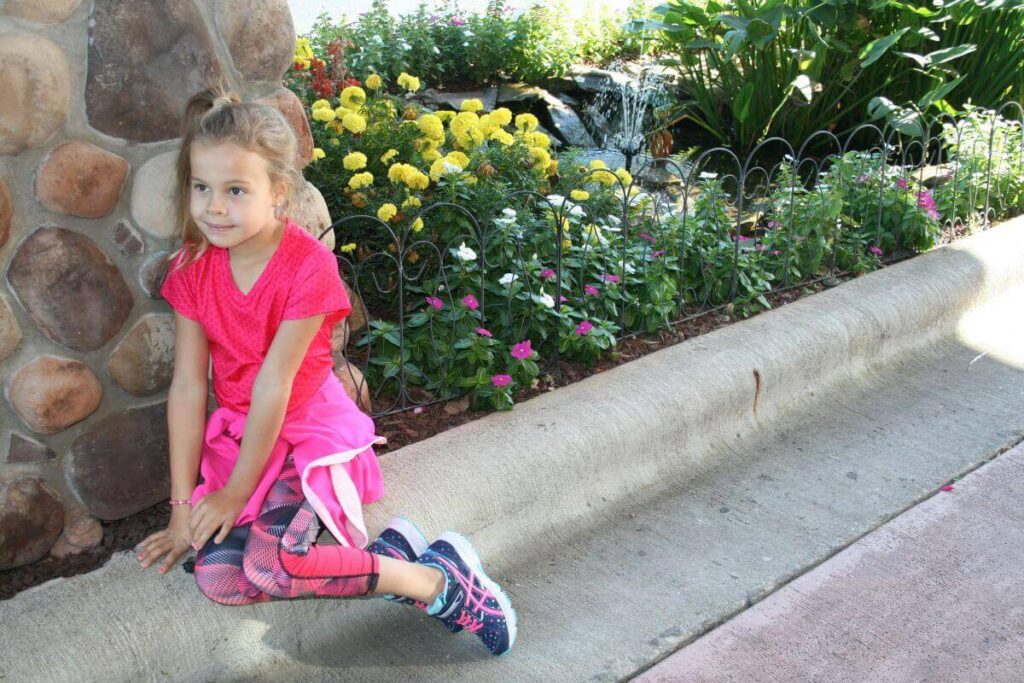 Girl sitting near front entrance to Comfort Inn & Suites Branson Meadows.